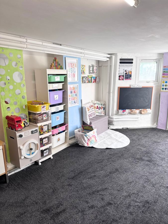 The playroom with colourful storage, a chalkboard and a play kitchen